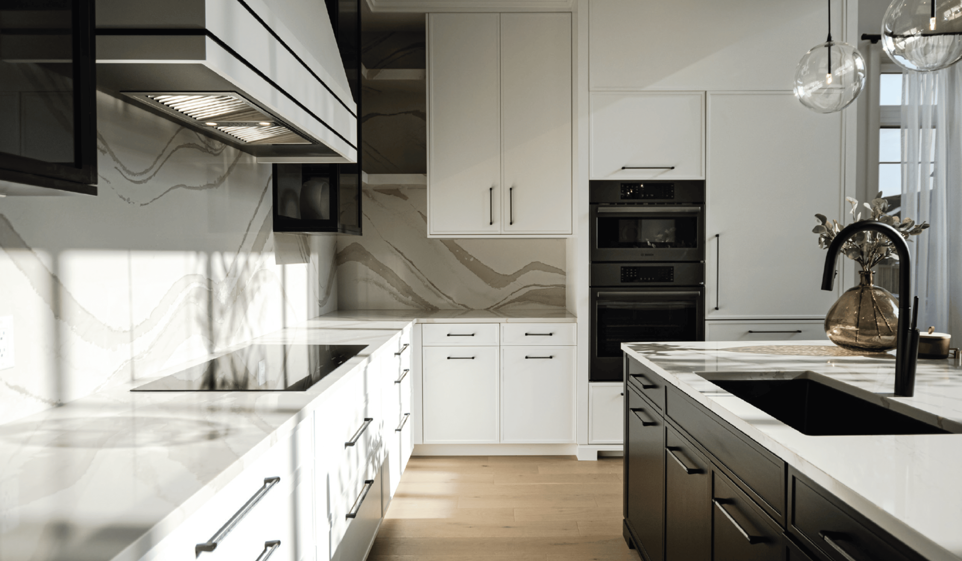 Model home kitchen featuring white marble countertops and sleek black finishes.